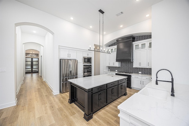 kitchen with white cabinets, pendant lighting, sink, and stainless steel appliances