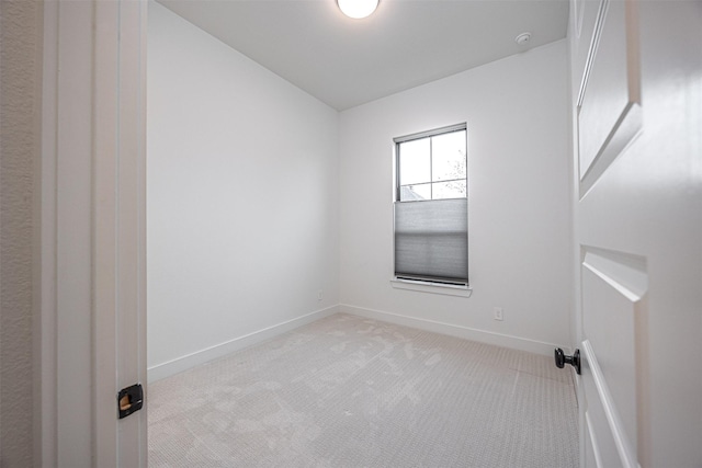 empty room featuring vaulted ceiling and light colored carpet