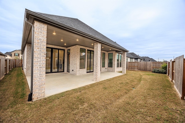 back of house featuring a yard and a patio area