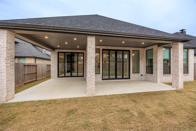 rear view of house featuring a patio and a lawn