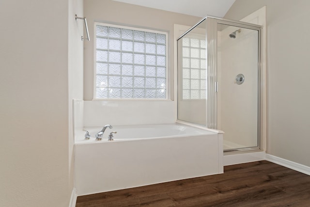 bathroom with wood-type flooring and shower with separate bathtub