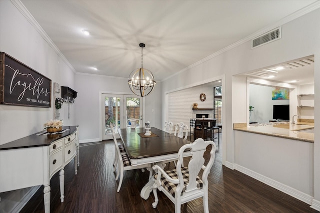 dining room featuring sink, an inviting chandelier, french doors, dark hardwood / wood-style floors, and crown molding