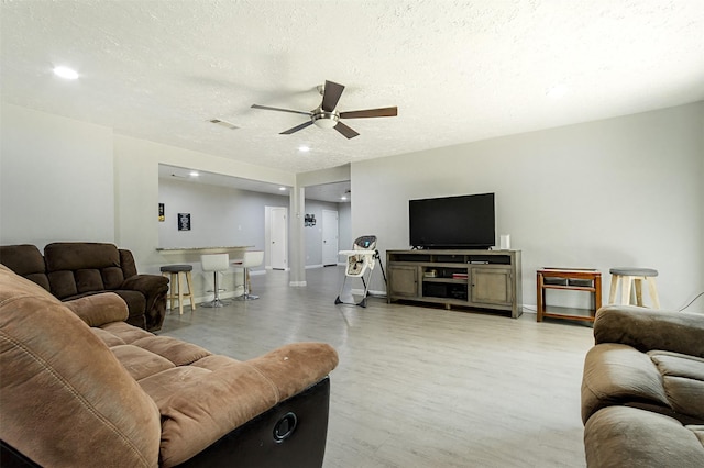 living room featuring a textured ceiling and ceiling fan