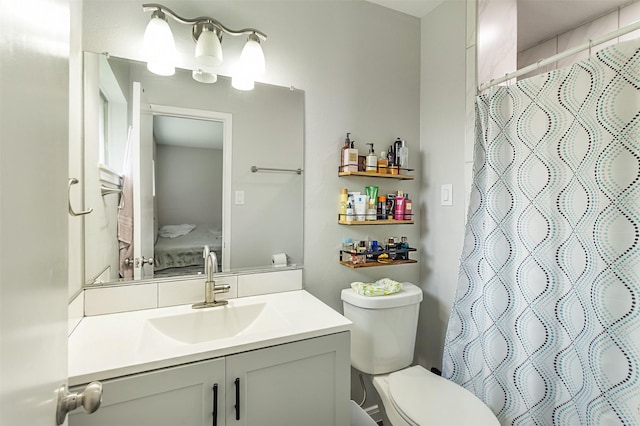 bathroom with toilet, vanity, and a shower with curtain