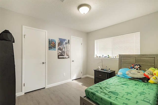 bedroom featuring a textured ceiling and hardwood / wood-style floors