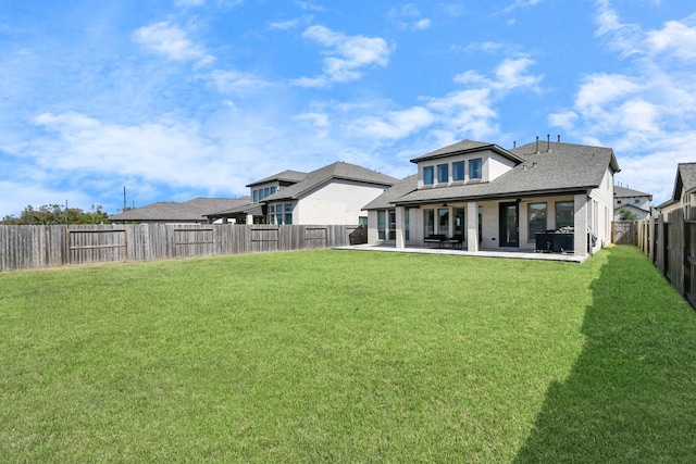 back of house with a yard and a patio