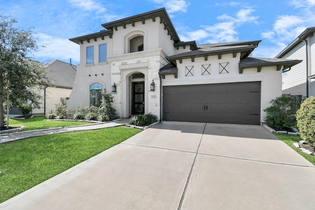 mediterranean / spanish home featuring a front yard and a garage