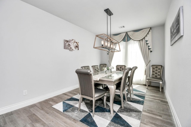 dining space with a notable chandelier and hardwood / wood-style flooring