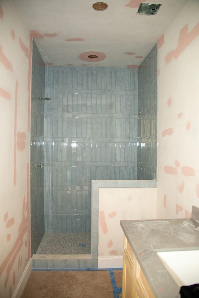 bathroom with tiled shower and vanity