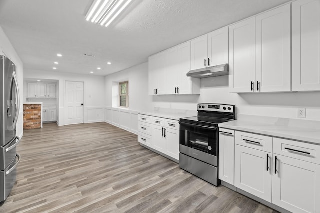 kitchen with light wood-type flooring, under cabinet range hood, white cabinetry, and appliances with stainless steel finishes