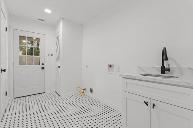 clothes washing area with hookup for a gas dryer, washer hookup, a sink, visible vents, and cabinet space