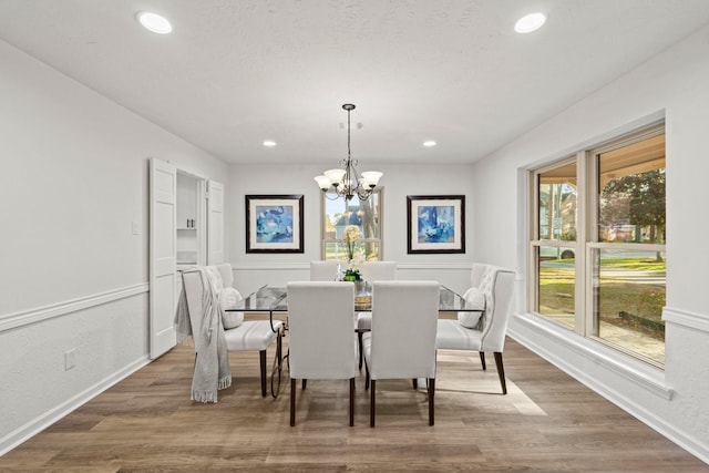 dining room featuring a chandelier, baseboards, wood finished floors, and recessed lighting