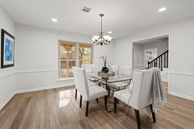 dining room with an inviting chandelier, visible vents, wood finished floors, and recessed lighting