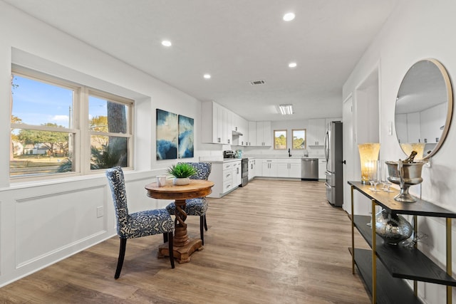 dining room with light wood-type flooring, visible vents, and recessed lighting