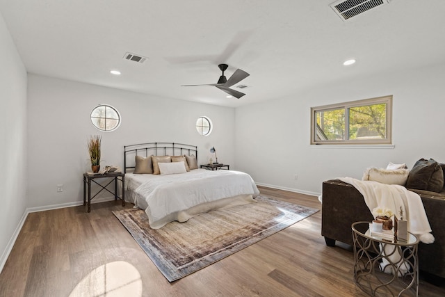 bedroom with visible vents, baseboards, and wood finished floors