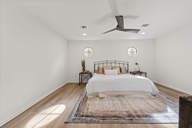 bedroom featuring baseboards, visible vents, ceiling fan, and wood finished floors