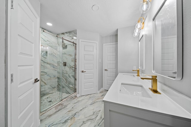 bathroom featuring a shower with door, vanity, and a textured ceiling