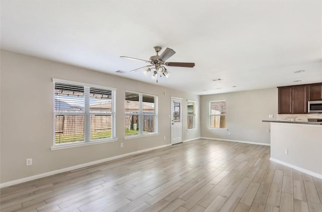 unfurnished living room featuring ceiling fan and light hardwood / wood-style flooring