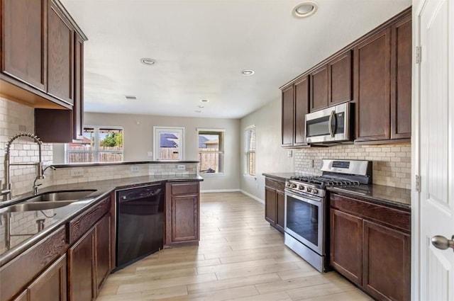 kitchen with a wealth of natural light, stainless steel appliances, decorative backsplash, and sink