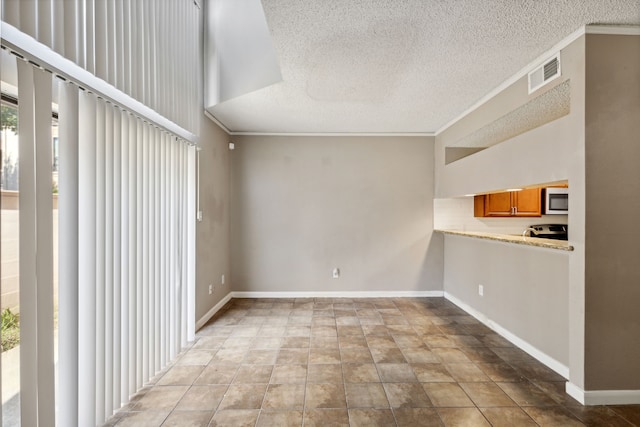 unfurnished living room with ornamental molding and a textured ceiling