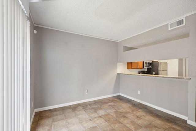 empty room with a textured ceiling and crown molding