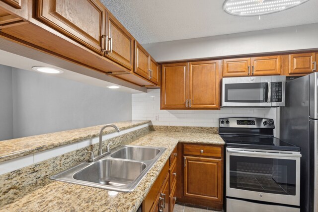 kitchen featuring appliances with stainless steel finishes, tasteful backsplash, and sink