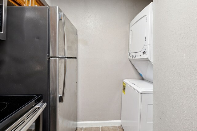 laundry area with tile patterned floors and stacked washer and dryer