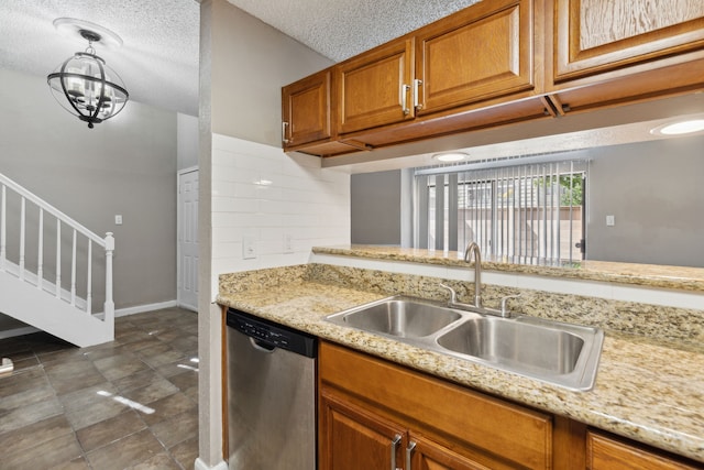 kitchen featuring sink, a textured ceiling, an inviting chandelier, stainless steel dishwasher, and hanging light fixtures