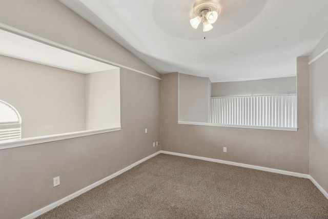 carpeted spare room featuring lofted ceiling and ceiling fan