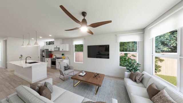 living room featuring sink, ceiling fan, light hardwood / wood-style flooring, and plenty of natural light