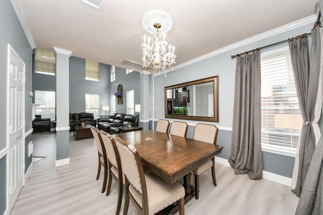 dining space featuring ornamental molding, light wood-type flooring, and an inviting chandelier