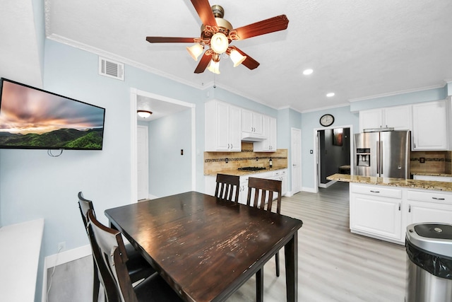 dining space featuring crown molding, ceiling fan, and light hardwood / wood-style flooring