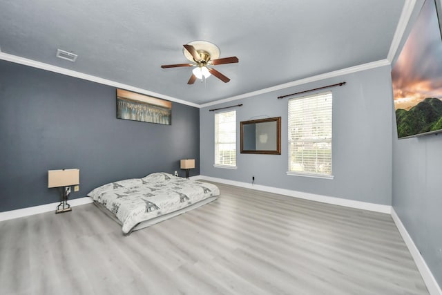 bedroom featuring crown molding, wood-type flooring, and ceiling fan