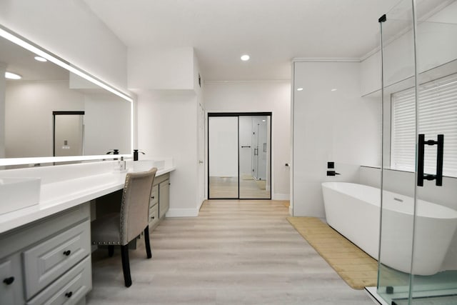 bathroom featuring independent shower and bath, vanity, hardwood / wood-style floors, and crown molding