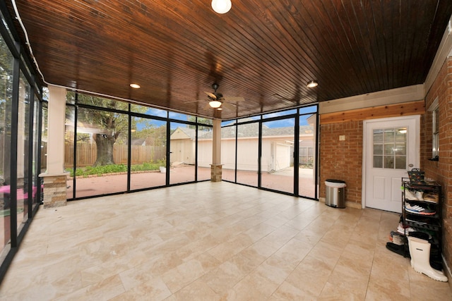 unfurnished sunroom with wooden ceiling and ceiling fan