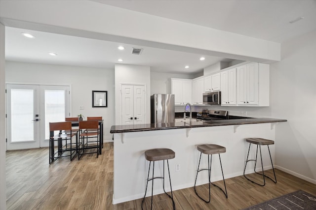 kitchen with sink, white cabinetry, kitchen peninsula, and appliances with stainless steel finishes