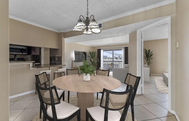 dining space featuring a textured ceiling, a chandelier, light tile patterned floors, and ornamental molding