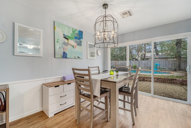 dining space featuring light wood-type flooring and a chandelier