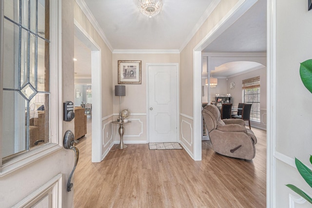 entrance foyer featuring ornamental molding and light hardwood / wood-style flooring