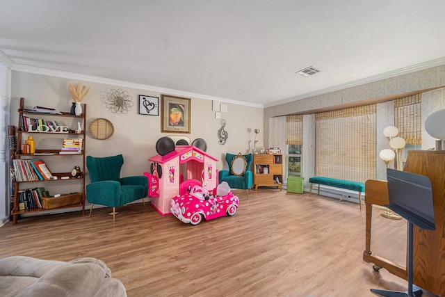 recreation room with ornamental molding and hardwood / wood-style flooring