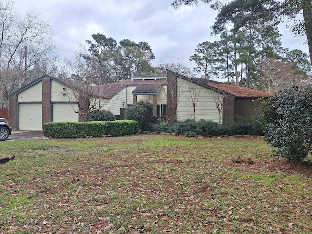 view of front of property featuring a front yard and a garage