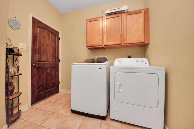 washroom with cabinets, separate washer and dryer, and light tile patterned floors