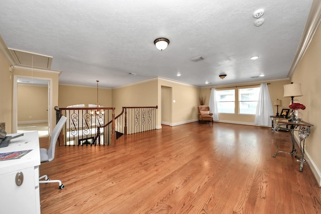 living room with a textured ceiling, ornamental molding, and light hardwood / wood-style flooring