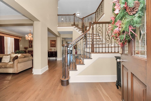 foyer entrance featuring ornamental molding, a chandelier, and hardwood / wood-style floors