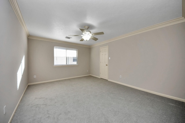 empty room featuring ceiling fan, ornamental molding, and carpet