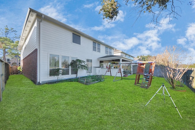 back of property featuring a yard and a playground