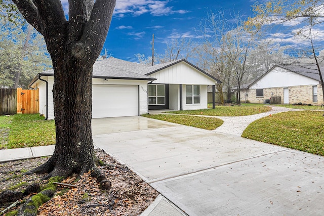 ranch-style home with a garage, central AC unit, and a front yard