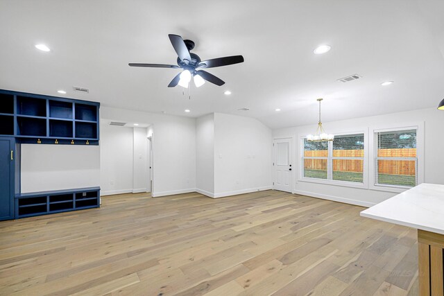 unfurnished living room featuring ceiling fan with notable chandelier and light hardwood / wood-style flooring