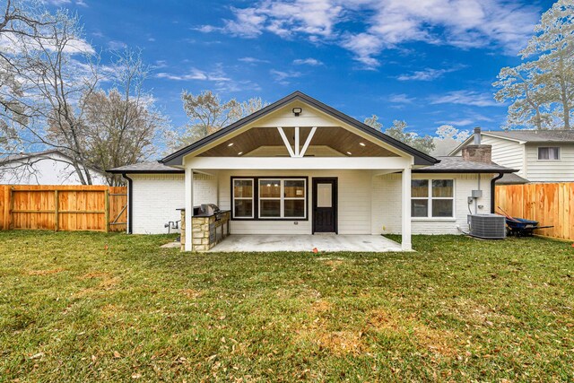 rear view of house with central AC unit, a patio area, and a lawn