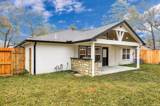 rear view of property featuring cooling unit, a lawn, ceiling fan, and a patio area